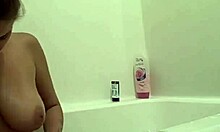 胸部丰满的棕发女郎在浴缸里展示她的阴部和阴部